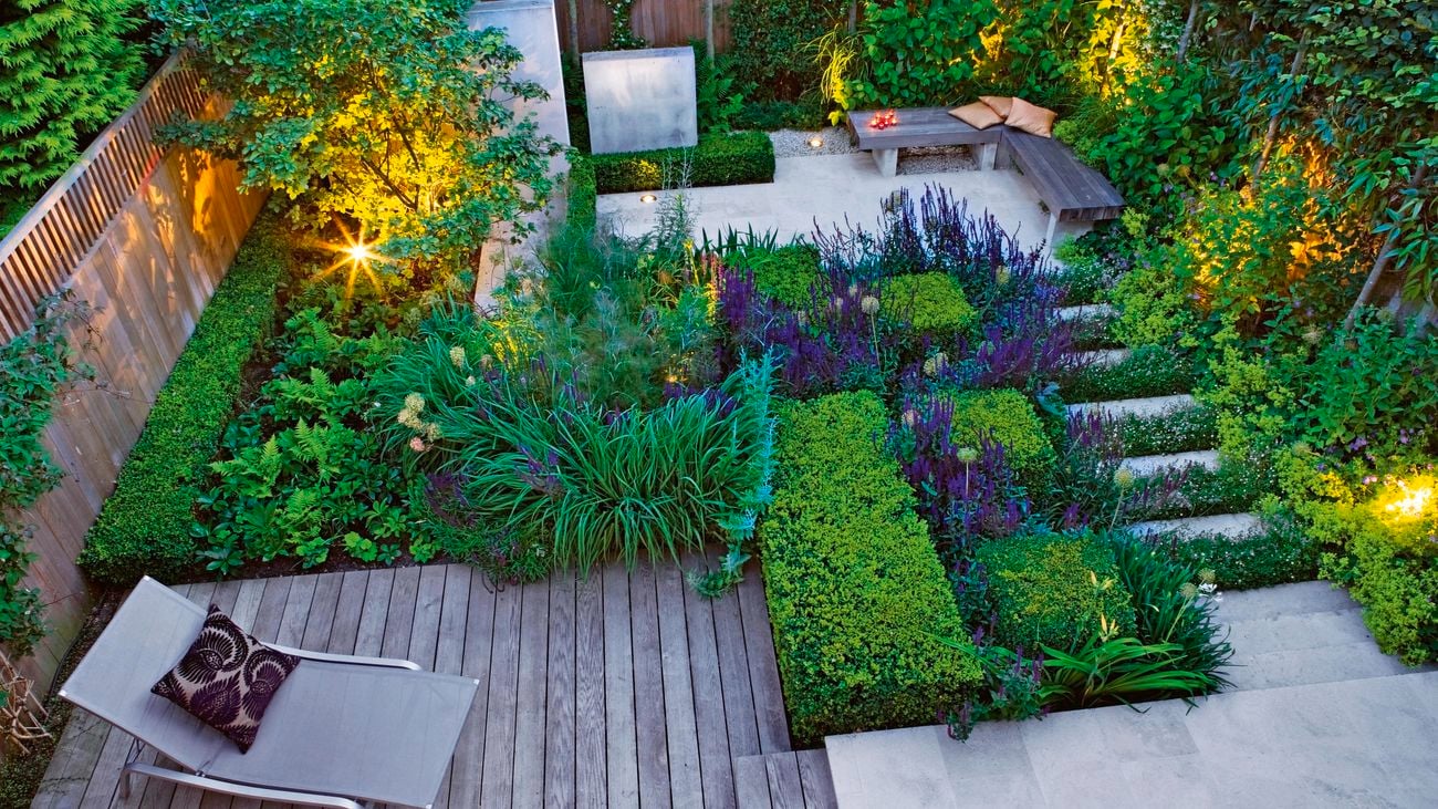 Backyard with pathways to outdoor seating surrounded by foliage