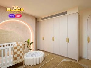 Neutral baby bedroom with brown and tan colours. Showcasing a cot and small ball pit in front of an arched feature wall with feature lighting. There is a wardrobe on the opposite wall.