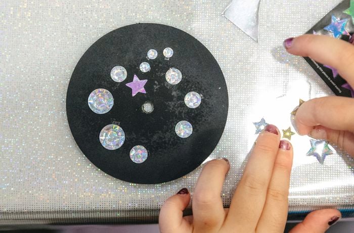 A circular coaster being decorated with stars