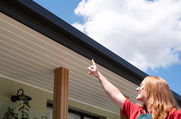 A woman pointing her finger to the roof.