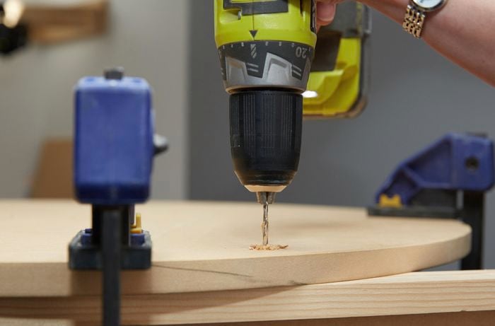 Person drilling hole into timber 