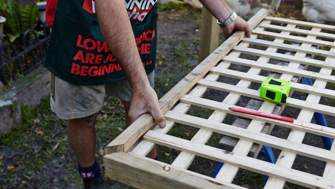 Person putting lattice fence together.