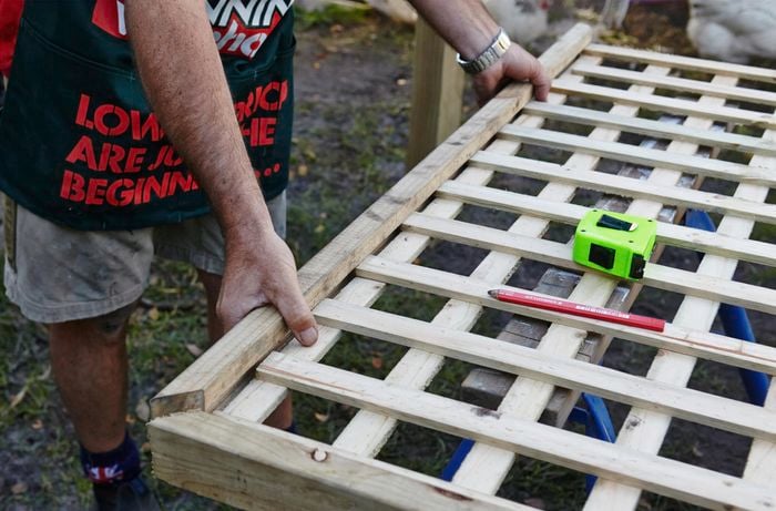 Person putting lattice fence together.