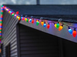 Colourful string lights attached to roof gutter.