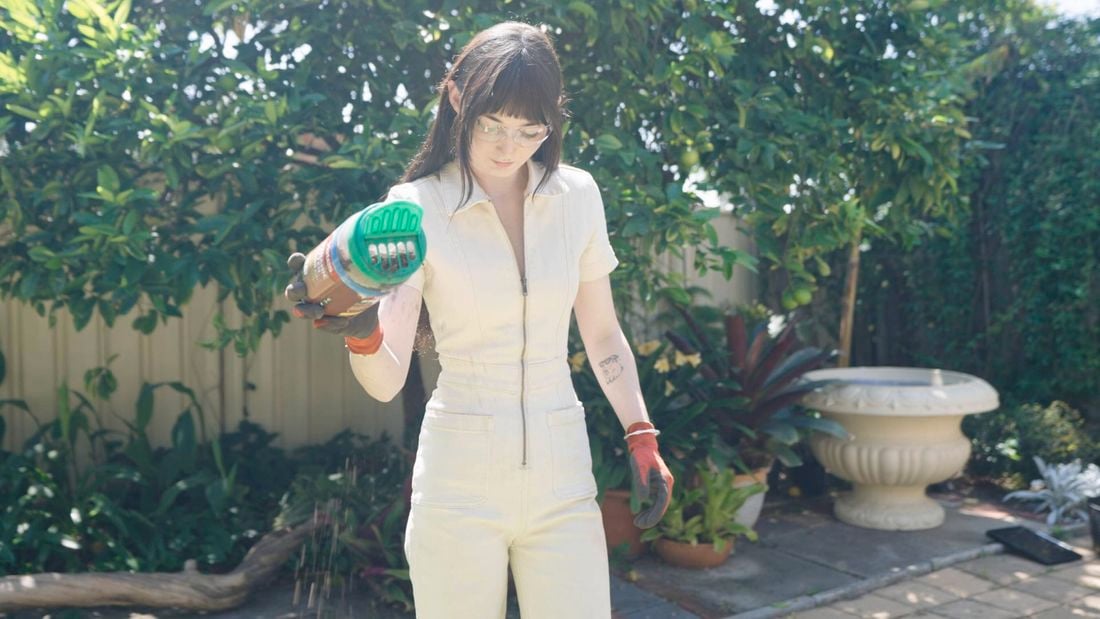 Person with gardening gloves holding Yates Lawn Shaker.