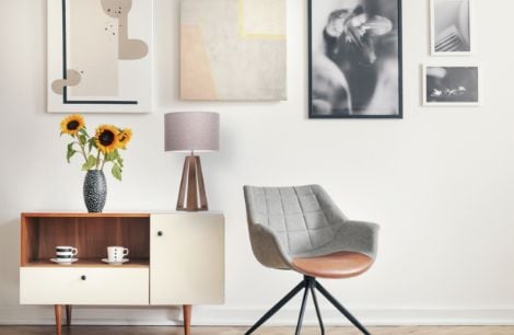 Black couch on a patterned rug next to floating book shelving