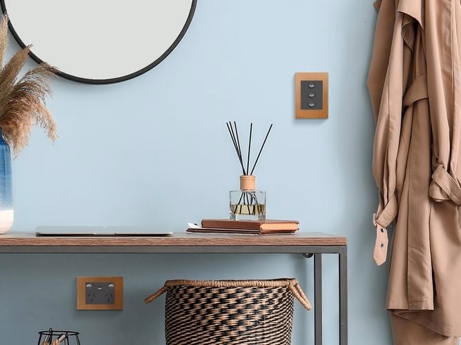 Wall painted blue with light switch that is cork coloured 