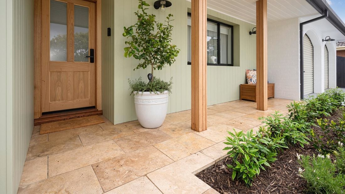 Image of a house with a paved tile pathway leading up to the front entrance. 