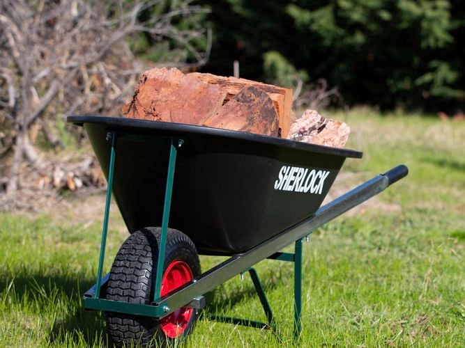 Tradesperson loading wheelbarrow with chopped wood