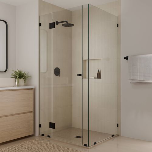Corner shower enclosure with clear glass panels, black fittings, and modern bathroom vanity.