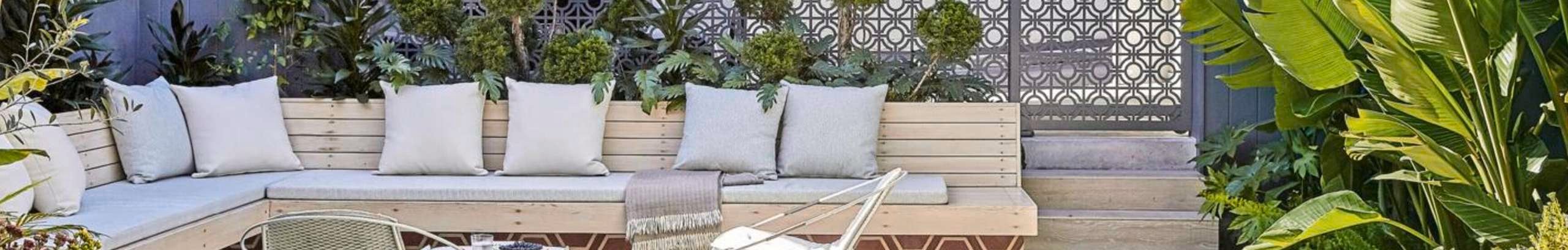 Elegant backyard with outdoor bench, table and chairs and plants and flowers