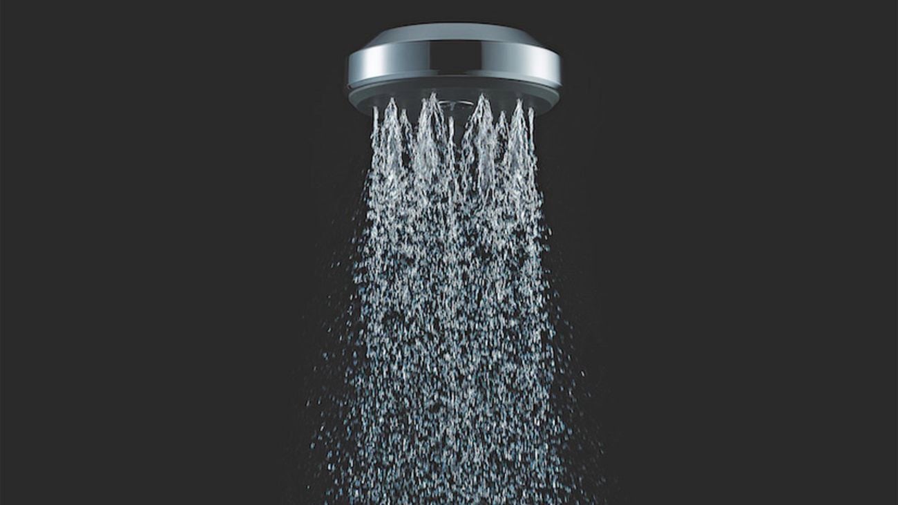 Water spraying from a Futura shower head isolated on black background