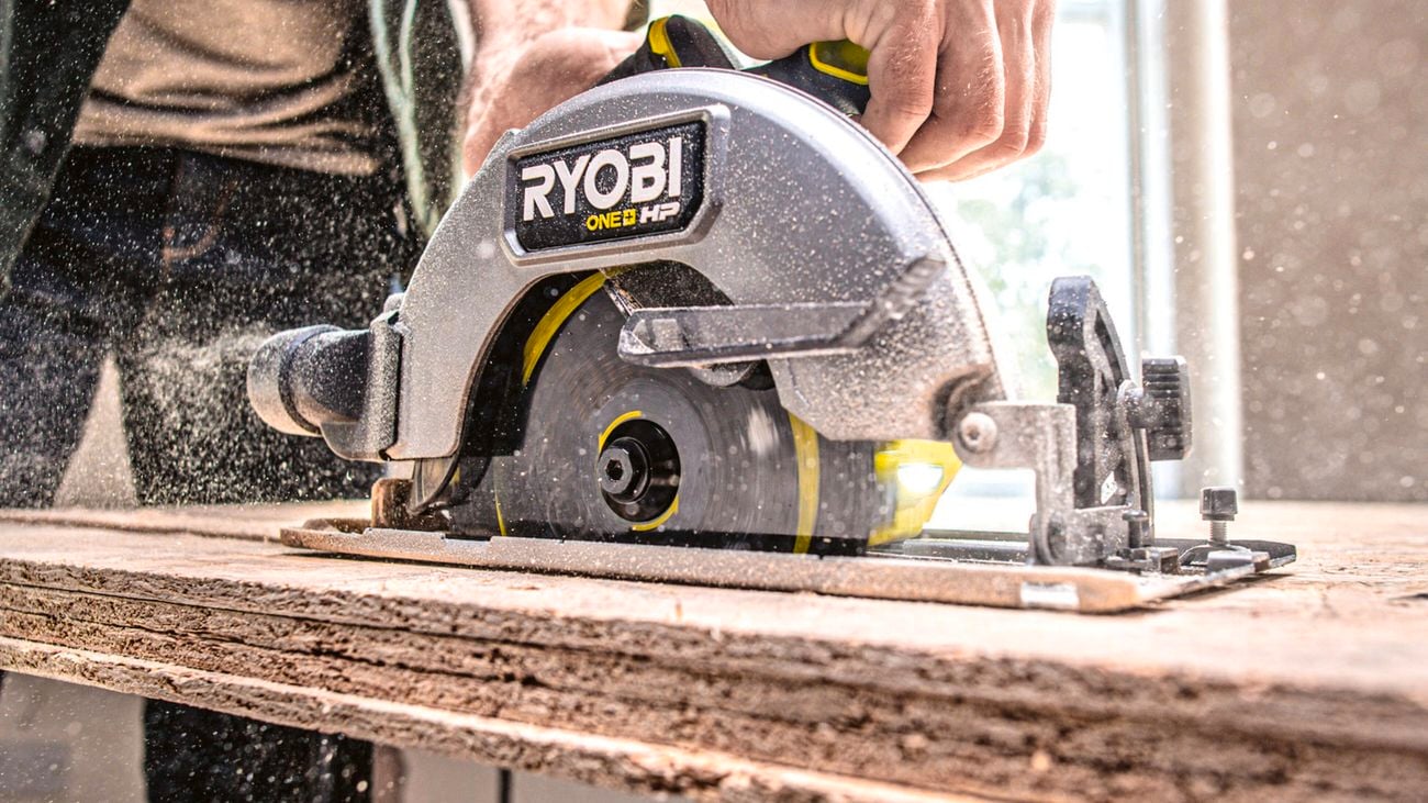  A person using a Ryobi circular saw to cut through a stack of boards