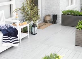 White outdoor decking area with planters and boots.