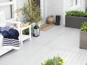 White outdoor decking area with planters and boots.