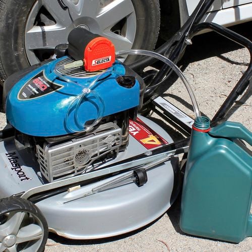 Oil changing kit set up to change oil in a lawnmower
