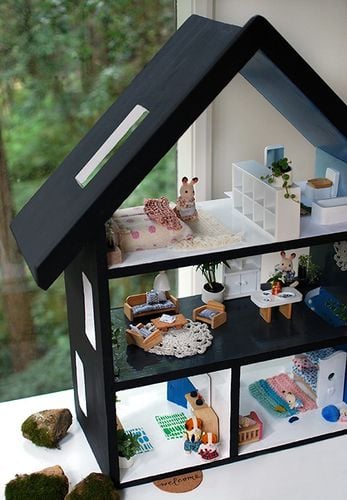 Closeup of a dollhouse inhabited by tiny rabbits