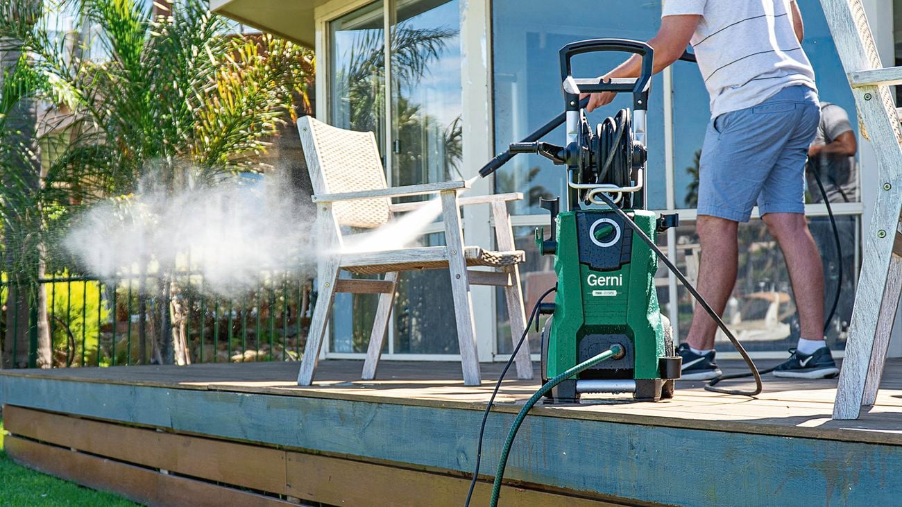 A person using a Gerni ‘7000’ high pressure washer to clean an outdoor patio.