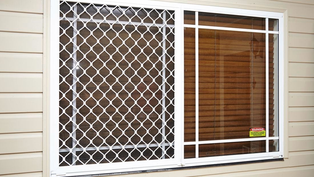 A security frame installed over a window fitted with venetian blinds