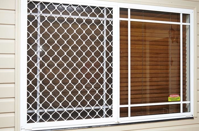 A security frame installed over a window fitted with venetian blinds