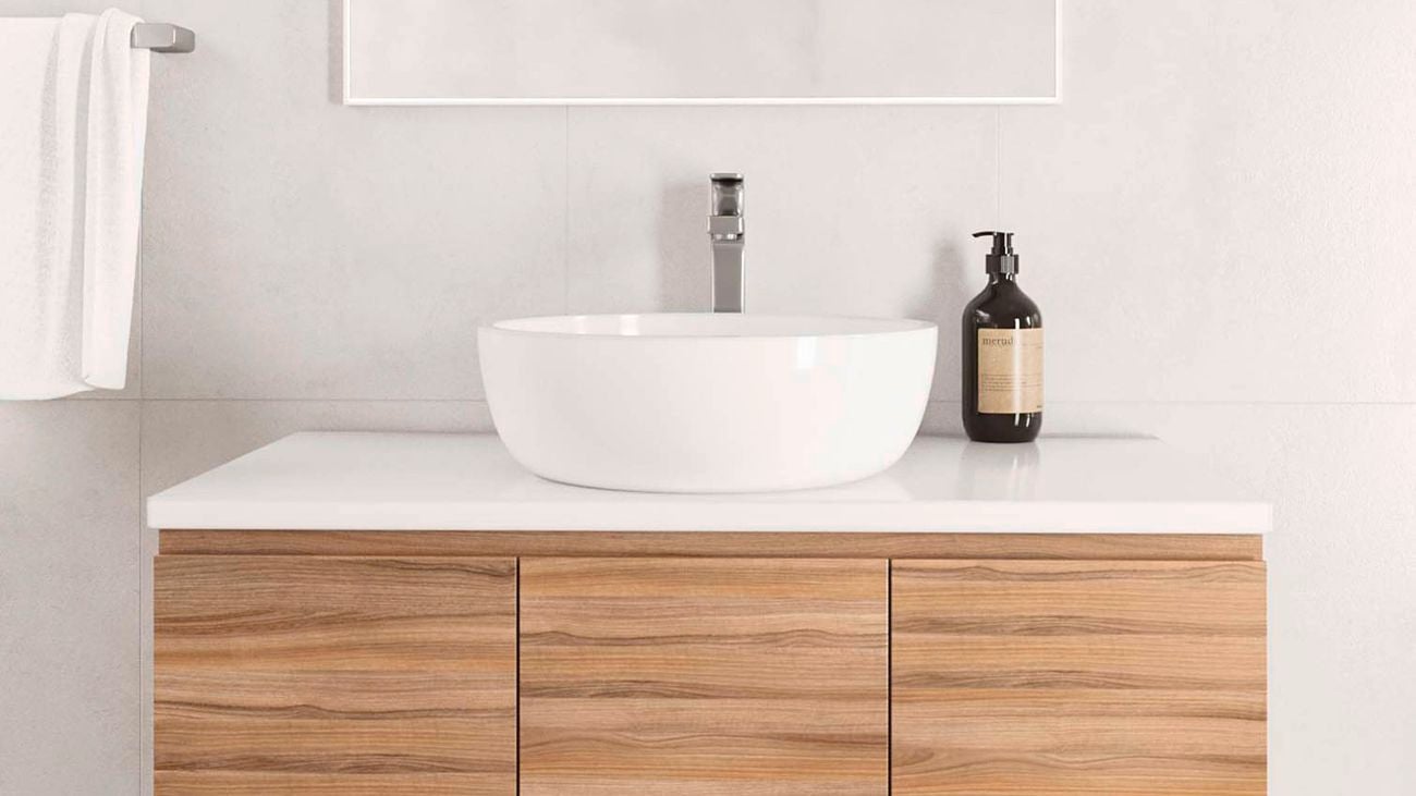 A wall-mounted vanity in a small bathroom, featuring an arched mirror and above-counter basin.