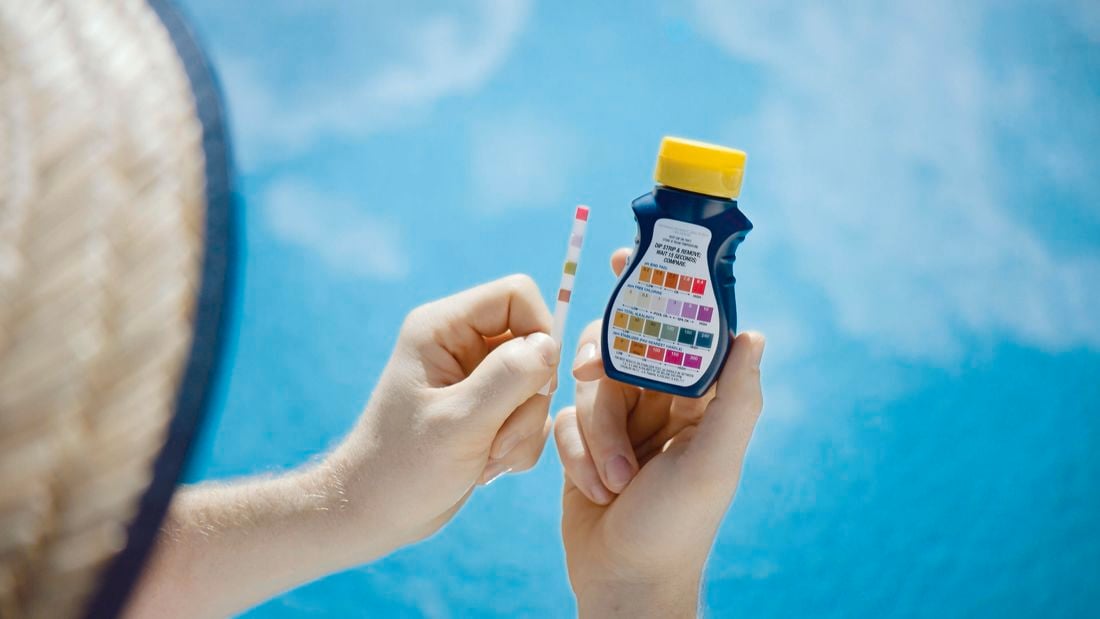 Man holding testing kit for pool 