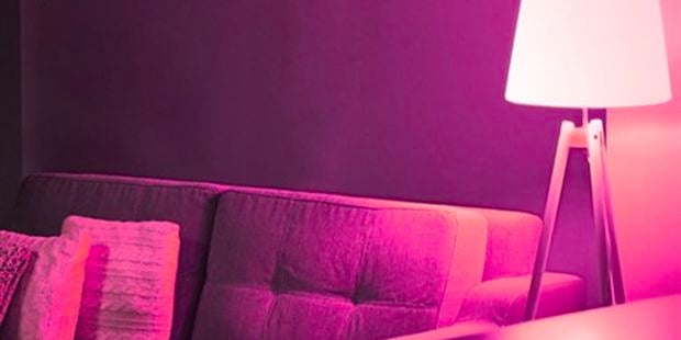 Living room with lamp with pink light.