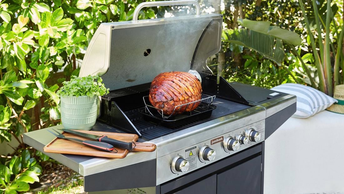 Glazed ham in a BBQ outdoors.