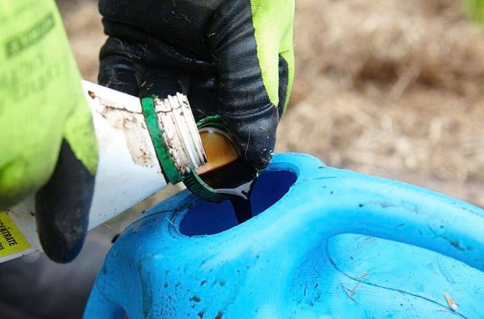 A capful of Seasol being added to a watering can