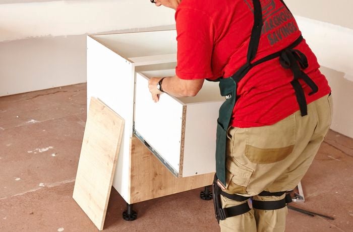Person removing top drawer from cabinet