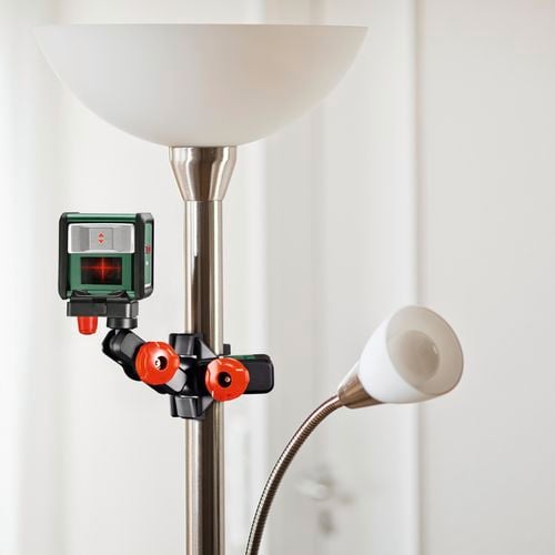 A laser level attached to a floor lamp by its screw on clamp