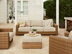  Wicker outdoor sofa and ottoman on a paved patio