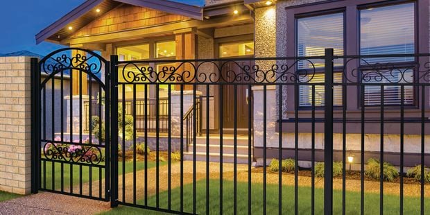 Fencing from masterworks installed in front of house with night lights on 