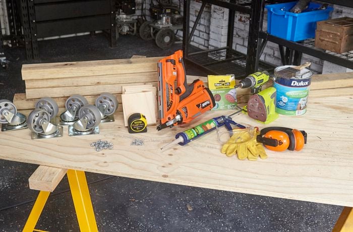 Tools and materials for the job, including timber, nail gun, wood glue, a power sander, screws, six castor wheels and more