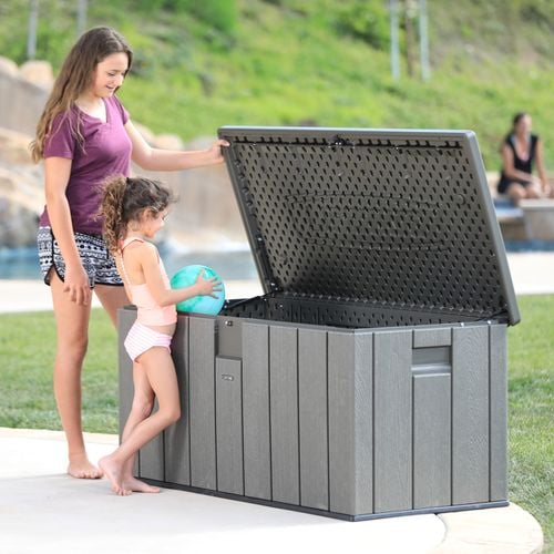 Child putting a ball into a plastic storage tub