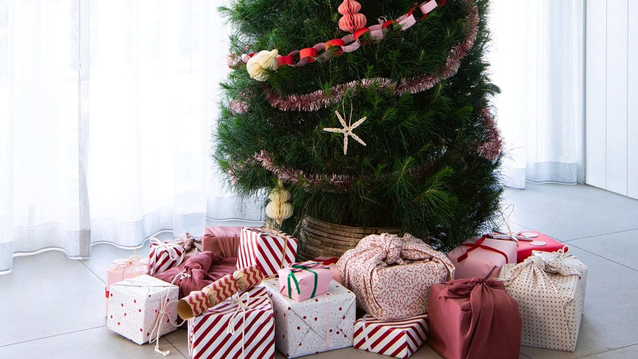 Christmas tree, covered in tinsel, surrounded by gifts.