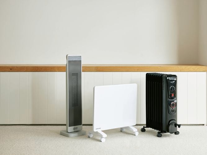 Three different styles of heaters in a room with carpet in it.
