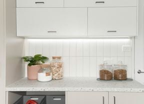 Laundry with cupboards, basket and jars.