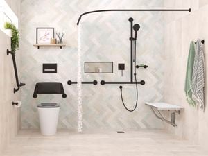 A bathroom, with a toilet, shower and bench seat against the wall in it.