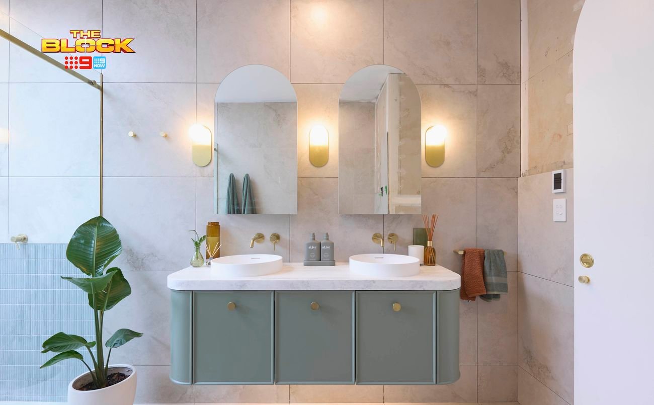 Blue and white bathroom with rounded vanity, 2 sinks and a shower