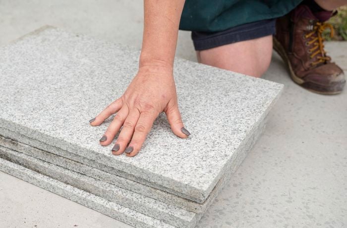 A person keeping his hand on pavers.
