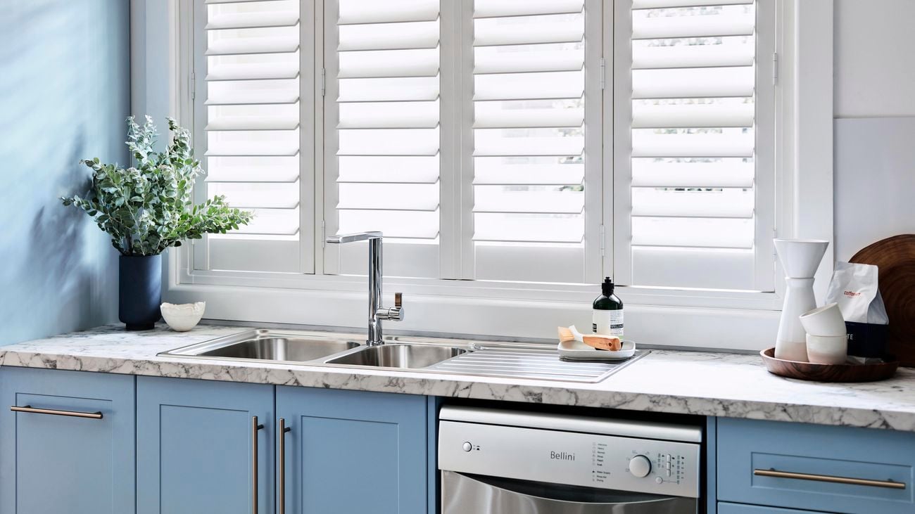 Kitchen with marble benchtop and blue cabinetry.