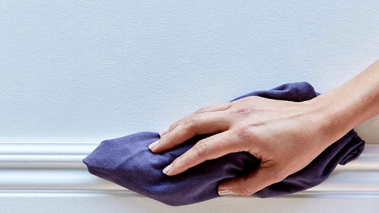 Hand with rag cleaning surface.