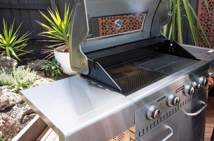 A four burner BBQ with clean grill plates