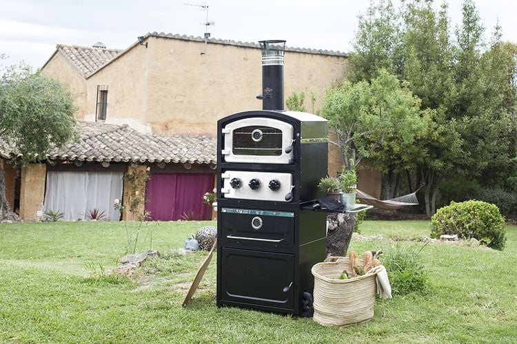 An outdoor stove with fresh herbs on a back lawn