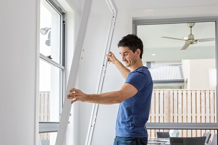 A tradesman applying a frame to a windowsill