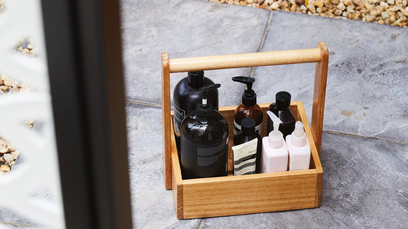 Timber caddy filled with bathroom products.