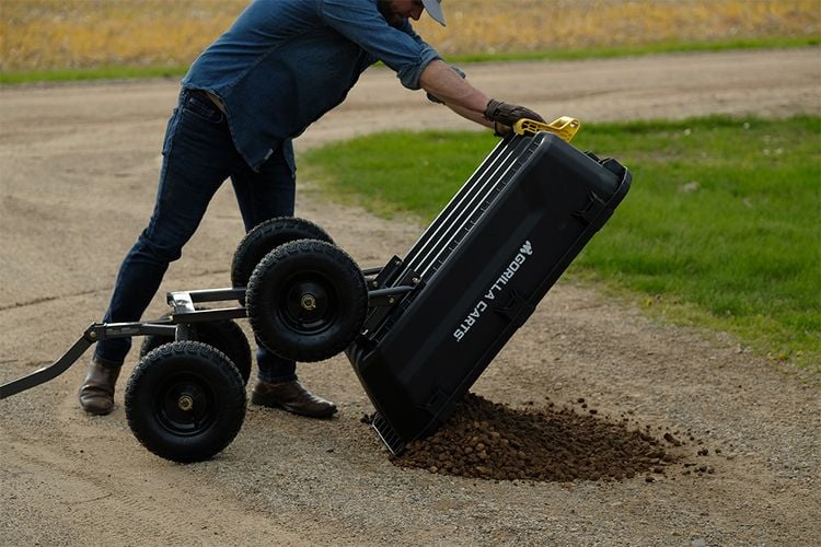 Dirt being dumped from a Gorilla Cart onto a gravel road