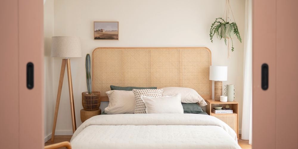 In a neatly decorated room, there are five basketballs hanging on the wall. A guitar is placed in the corner, alongside a study desk and chair. Additionally, there is a small bed with a brown beanbag