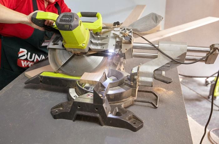 Person cutting timber on angle using circular saw